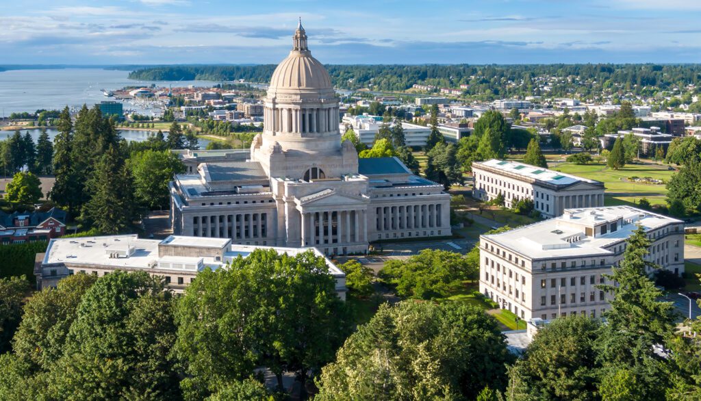 High-angle view of the Washington State Capitol and Department of Commerce building in Olympia, WA. Government buildings and surrounding parkland.